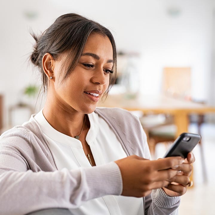 Lady using her smartphone in her home