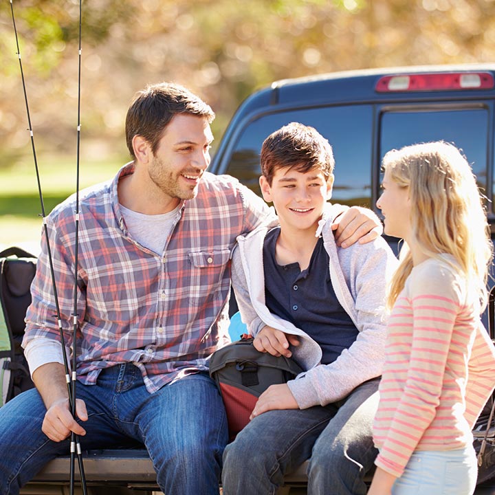 Father and his kids on a fishing trip in a pickup truck