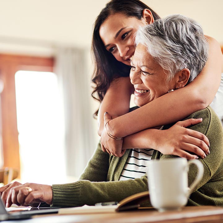 A grandmother and granddaughter looking at a laptop computer