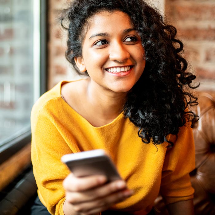 Young lady using her smartphone in a coffee shop