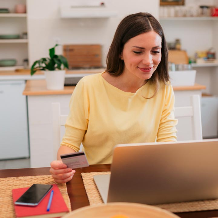 Lady using a credit or debit card on a laptop computer