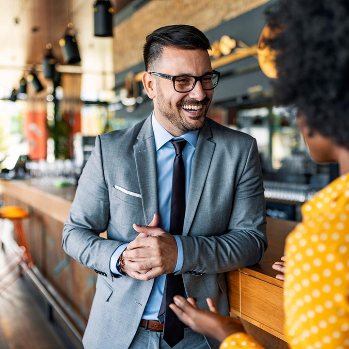 A man talking to a lady in a restaurant