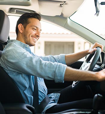 A man driving a new car